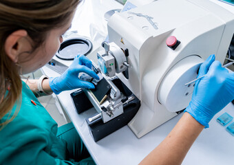 Laboratory assistant works on a rotary microtome section and making microscope slides