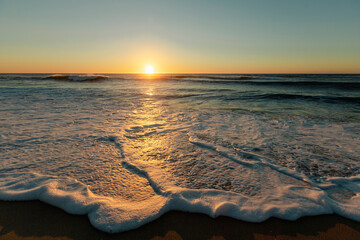 Foam surf on the Atlantic coast during a beautiful sunset.