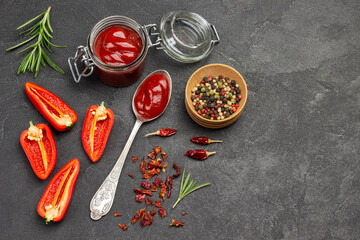 Tomato sauce in spoon and in jar.