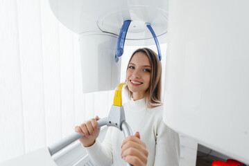 A young woman makes a CT scan of the jaw, a circular snapshot of the jaw in modern dentistry. Dental prosthetics, treatment and teeth whitening. Radiology, panoramic scanner.