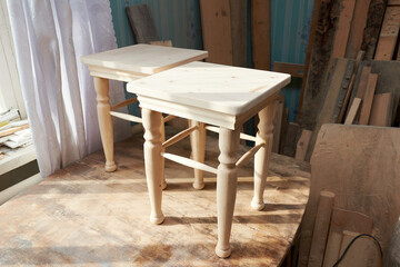 Stool making in woodworking workshop. Interior of the carpentry workshop in the rays of sunlight at home.