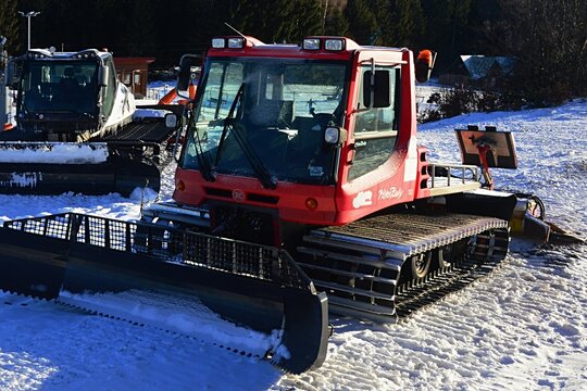 Snow groomers KassBohrer Setra and Prinoth parked on top of ski slope on Donovaly Park Snow ski resort, central Slovakia, Little Fatra mountains. January 2022 afternoon sunlight. 