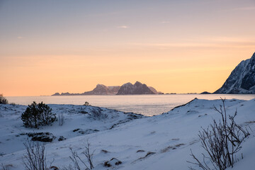 Scenery of mountain with snow pile on coastline in the evening on winter at Lofoten Islands