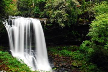 A serene waterfall flows in a lush forest in  the Appalachian Mountains of North Carolina