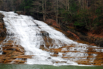 A cascading waterfall, Buttermilk Falls near Ithaca New York flows into a lower basin in a park