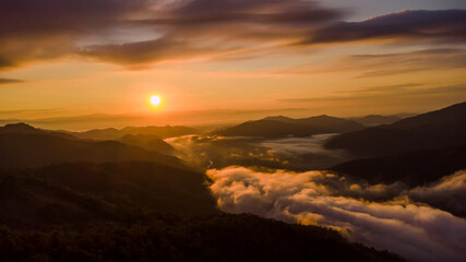 sunset and white mist or cloud scenic aerial view. Flying through the clouds and fog above mountain tops.	