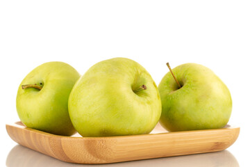 Several sweet green apples on a bamboo plate, close-up, isolated on white.