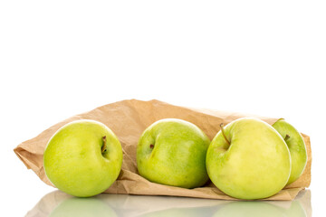 Several sweet green apples with a package of paper, close-up, isolated on white.