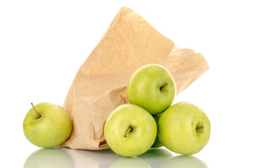 Several sweet green apples with a package of paper, close-up, isolated on white.