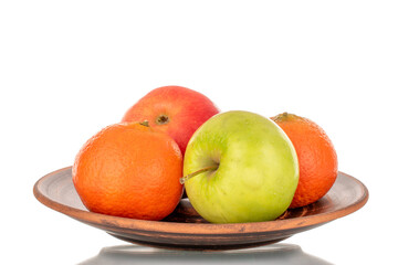 Two juicy apples, green, red and two tangerines on a plate of clay close-up, isolated on white.