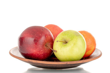 Two juicy apples, green, red and two tangerines on a plate of clay close-up, isolated on white.