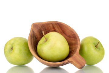 Three sweet green apples with a wooden cup, close-up, isolated on white.