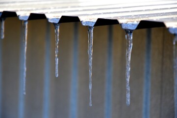 Icicles hanging from a metal roof. Frosty, sunny morning. 