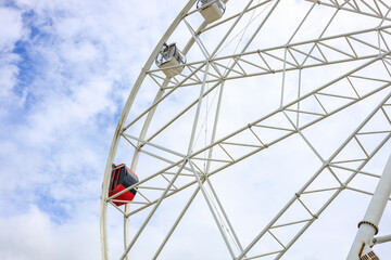 a red cab on a Ferris wheel among white cabins