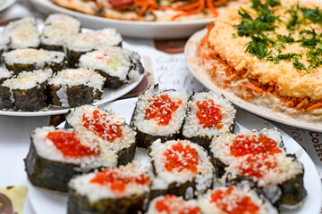 On the festive table are homemade sushi with red caviar, Japanese food.