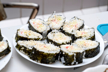 Homemade sushi, cut into pieces, are on the plates.