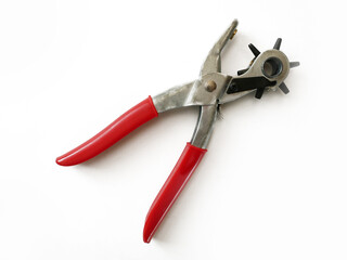 Puncture holes in the strap using a punch isolated on white background. Belt Hole Puncher Power...