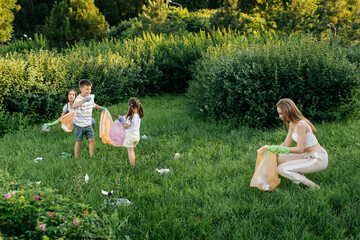 A group of adults and children together at sunset is engaged in garbage collection in the park....