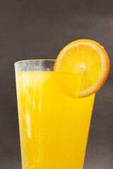 Glass of fresh orange juice with fruits cut in half and sliced isolated on gray background, clipping path