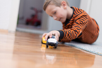 Boy playing toy cars. Kid with toys. Child and car at home