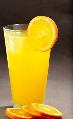 Glass of fresh orange juice with fruits cut in half and sliced isolated on gray background, clipping path