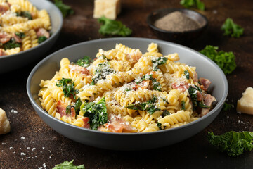 Fusilli pasta with bacon, kale and parmesan cheese. Healthy food