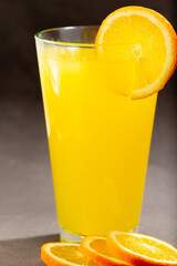 Glass of fresh orange juice with fruits cut in half and sliced isolated on gray background, clipping path