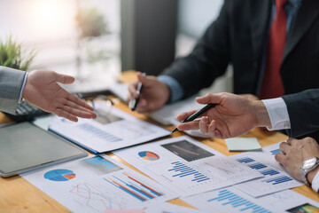 Business people meeting explaining the financial graph data and marketing plan. Group of business people at meeting assessment the state of business investment and marketing.