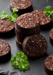Raw Black Pudding with parsley on rustic stone board