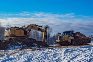 Articulated Dump Truck and excavator on road buid © Micha