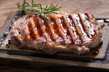 grilled meat with rosemary on a wooden board