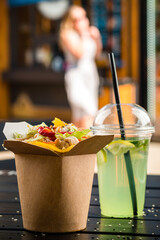 Chinese noodles with chicken and vegetables in a cardboard box on a dark background