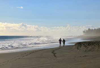 running au coucher de soleil sur la plage de saint leu à la réunion au bord de l'océan indien avec traces sur le sable
