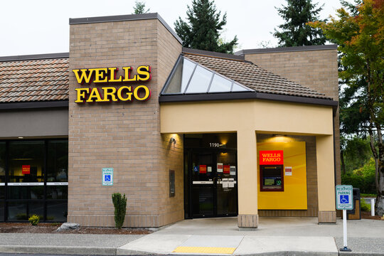 Issaquah, WA, USA - September 06, 2021; Wells Fargo bank branch in Issaquah Washington.  The lights illuminate the ATM machine and the entrance under an awning
