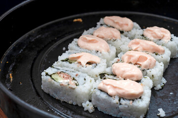 Sushi pastes covered with rice are placed on a baking dish.
