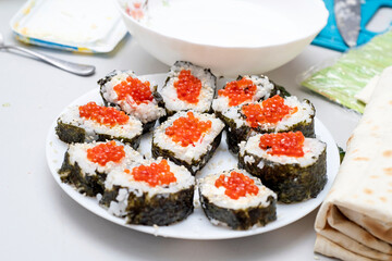 Plate with Japanese sushi and red caviar.