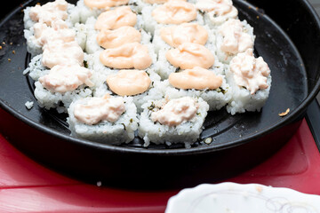 Homemade sushi covered with pate on a baking sheet.