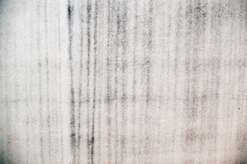 Rough plastered wall with damp vertical patches