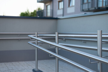 Stainless steel handrail on a ramp for disabled persons in modern housing area