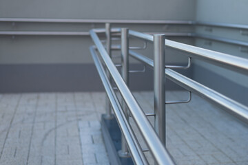 Stainless steel handrail on a ramp for disabled persons in modern housing area