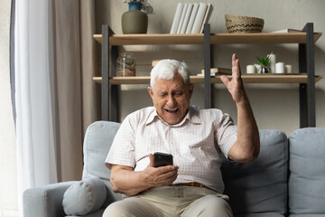 Overjoyed sincere old mature 80s man feeling excited looking at smartphone screen, reading message...