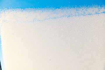 Snow structure on a skylight with blue sky ice crystals