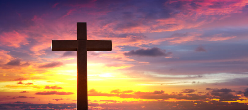 Silhouette of crucifix cross at sunset sky.