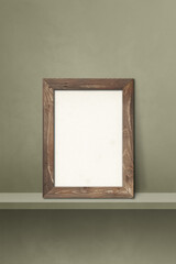 Wooden picture frame leaning on a green shelf. 3d illustration. Vertical background