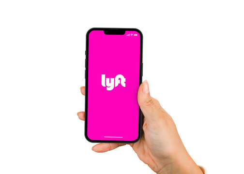 Female hand holding a smartphone iPhone 13 Pro with Lyft app on the screen. White background. Rio de Janeiro, RJ, Brazil. January 2022