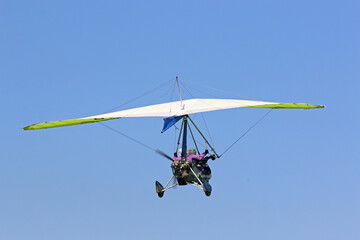 Fototapeta na wymiar Ultralight airplane flying in a blue sky 