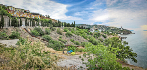 Fototapeta na wymiar View from the mountain to a bicycle camping with a tent on the Black Sea coast, Malorechenskoye, Crimea.