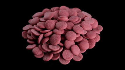 Ruby chocolate chips on black background. Confectionery concept