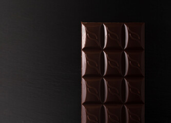 chocolate bar on a black flat stone in low light