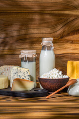 Dairy products. Bottles with milk, cheese, sour cream, butter on a wooden background
